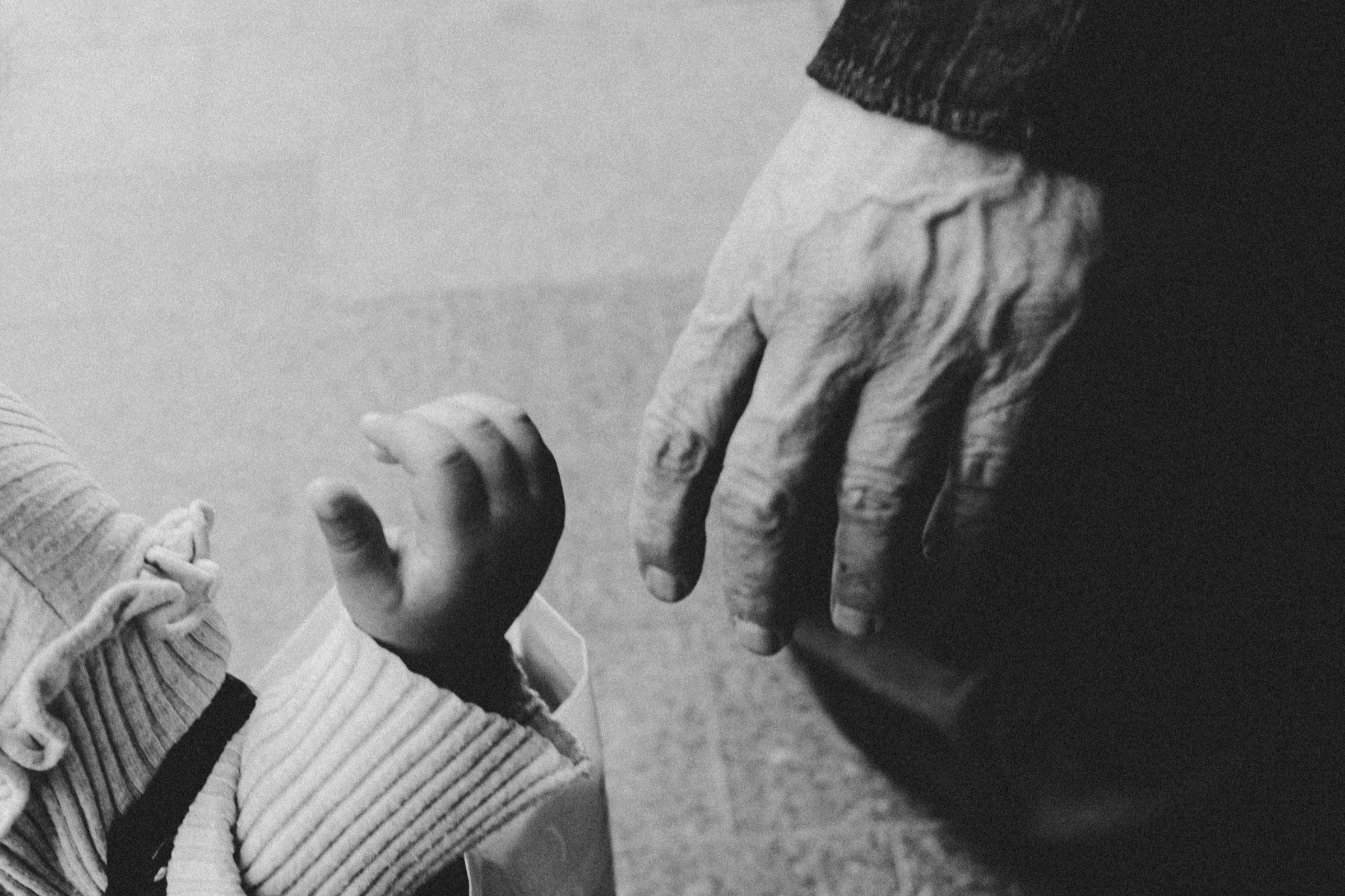 A candid shot of an elderly woman reaching out to hold a child's hand in Sidon city, Lebanon, 2024.